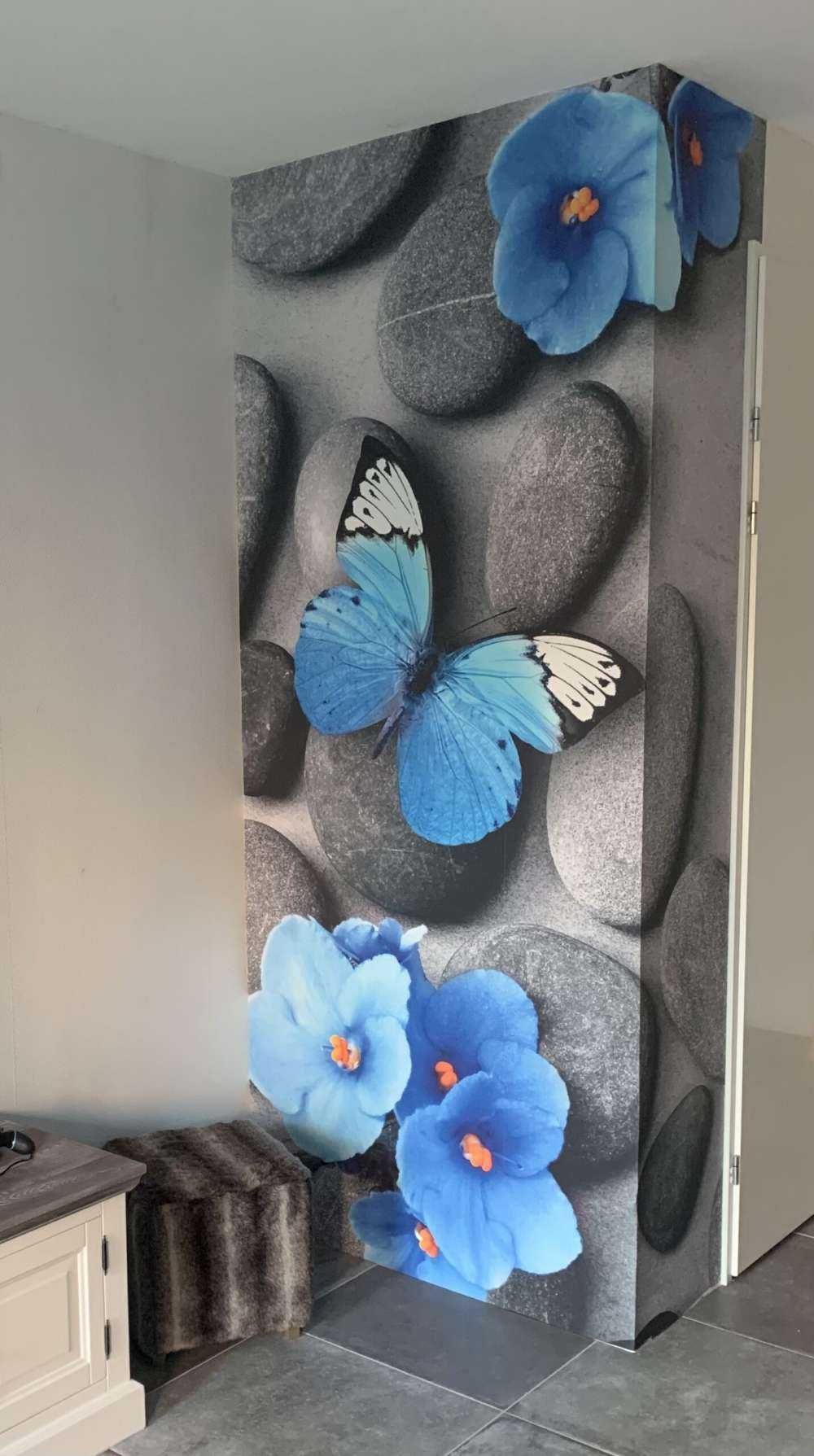 Grijze stenen met een blauwe vlinder en bloemen