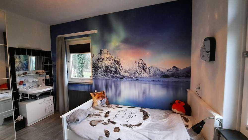 Northern lights over a frozen ocean and mountains