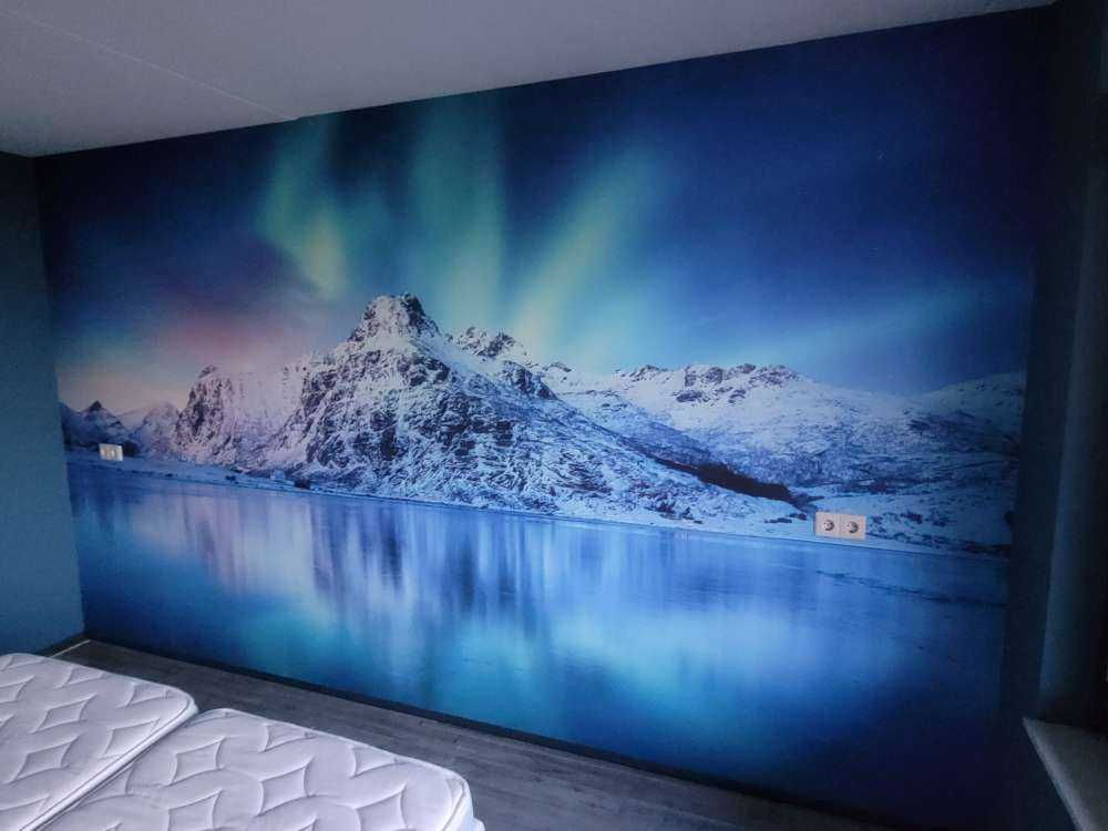 Northern lights over a frozen ocean and mountains