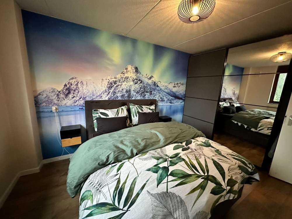 Northern lights over a frozen ocean and mountains