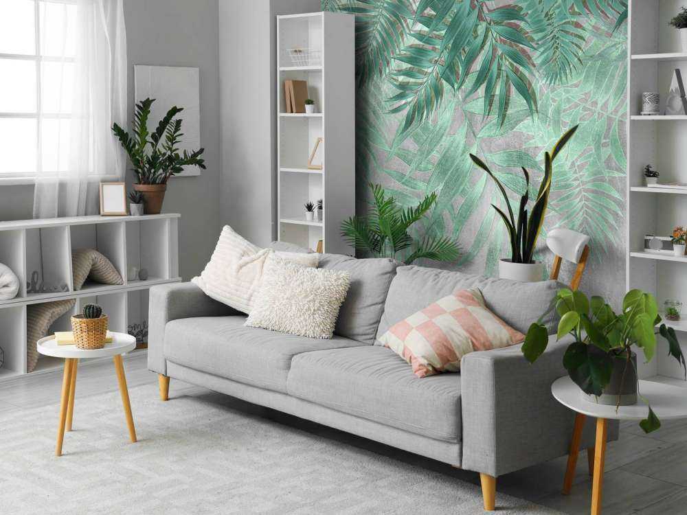 Green palm leaves with gray concrete wall