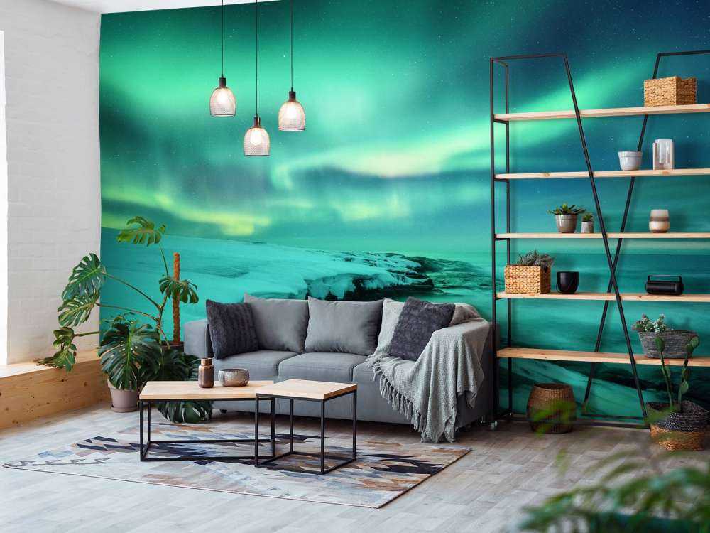 Green northern lights above snowy rocks