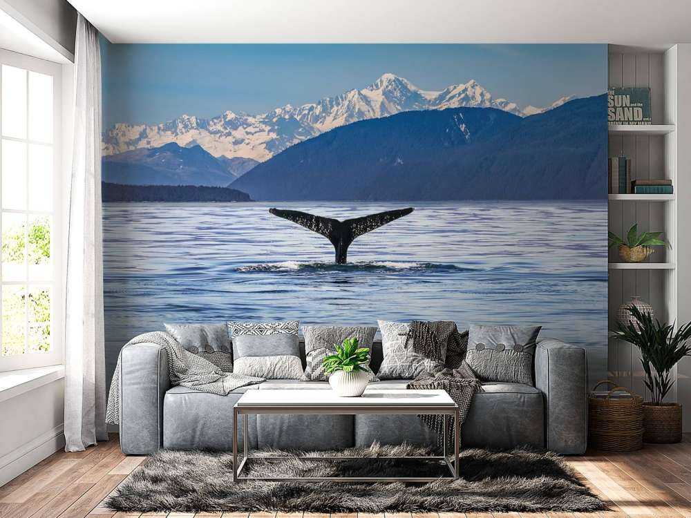 Diving whale with mountains in the background