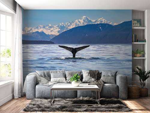 Diving whale with mountains in the background