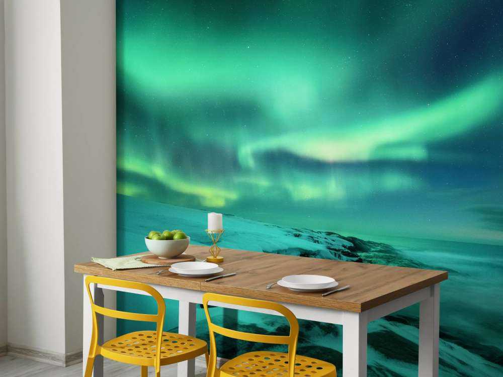 Green northern lights above snowy rocks