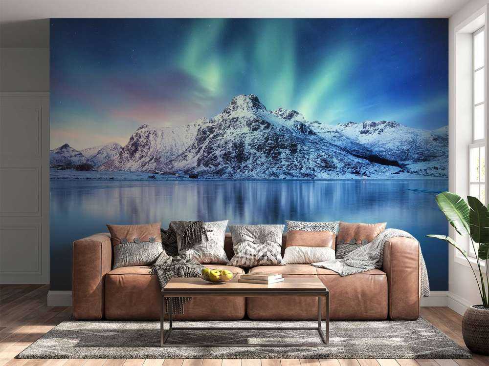 Northern lights over a frozen ocean and mountains