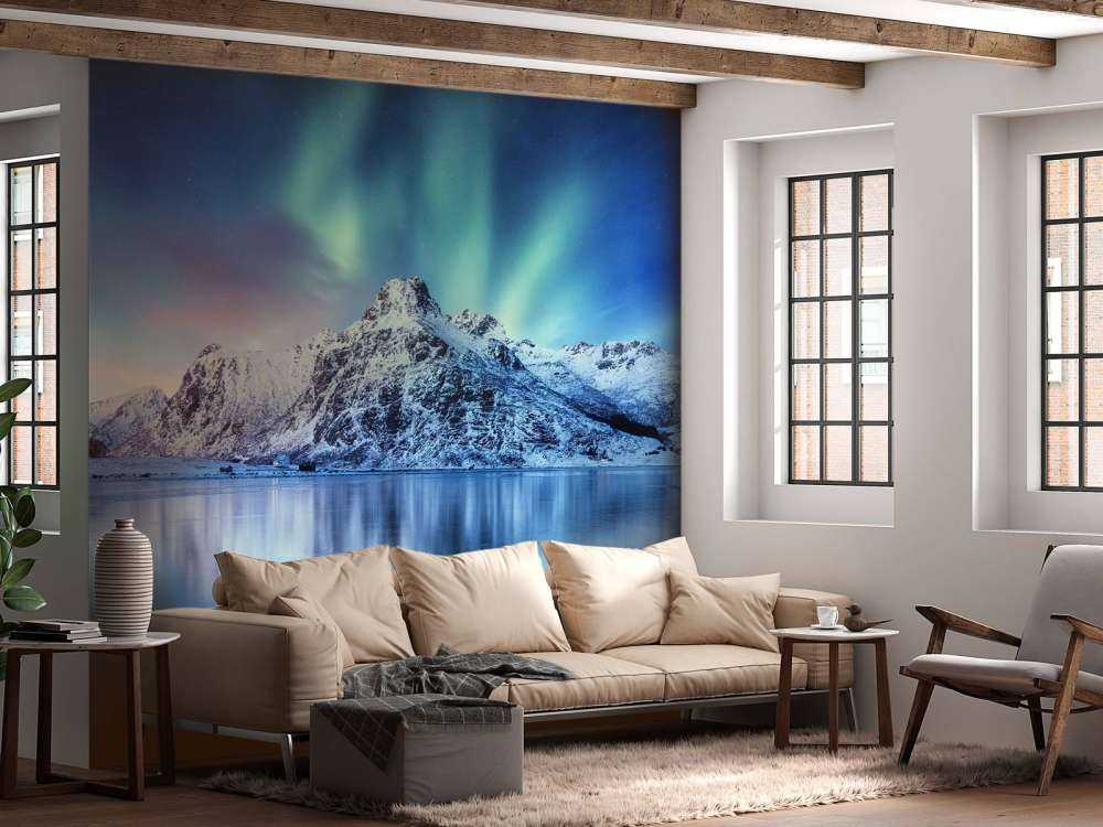 Northern lights over a frozen ocean and mountains