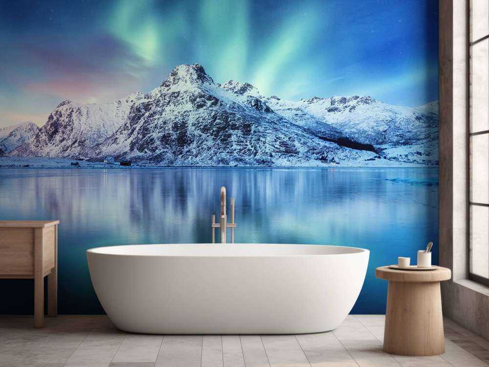 Northern lights over a frozen ocean and mountains