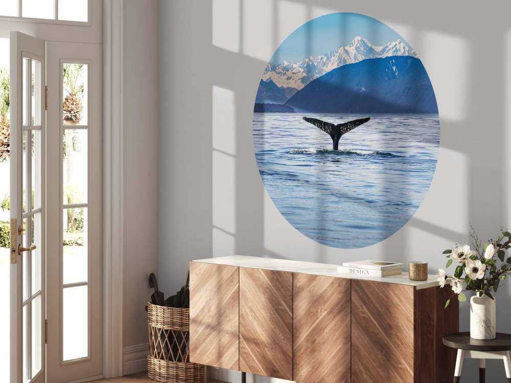 Diving whale with mountains in the background