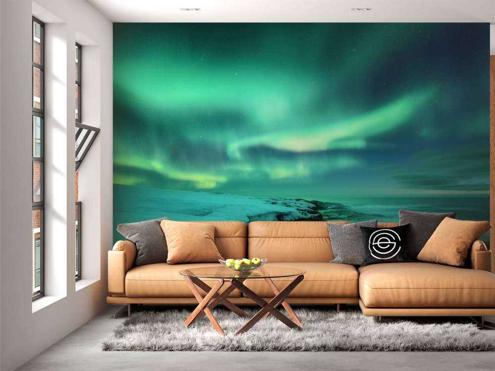 Green northern lights above snowy rocks