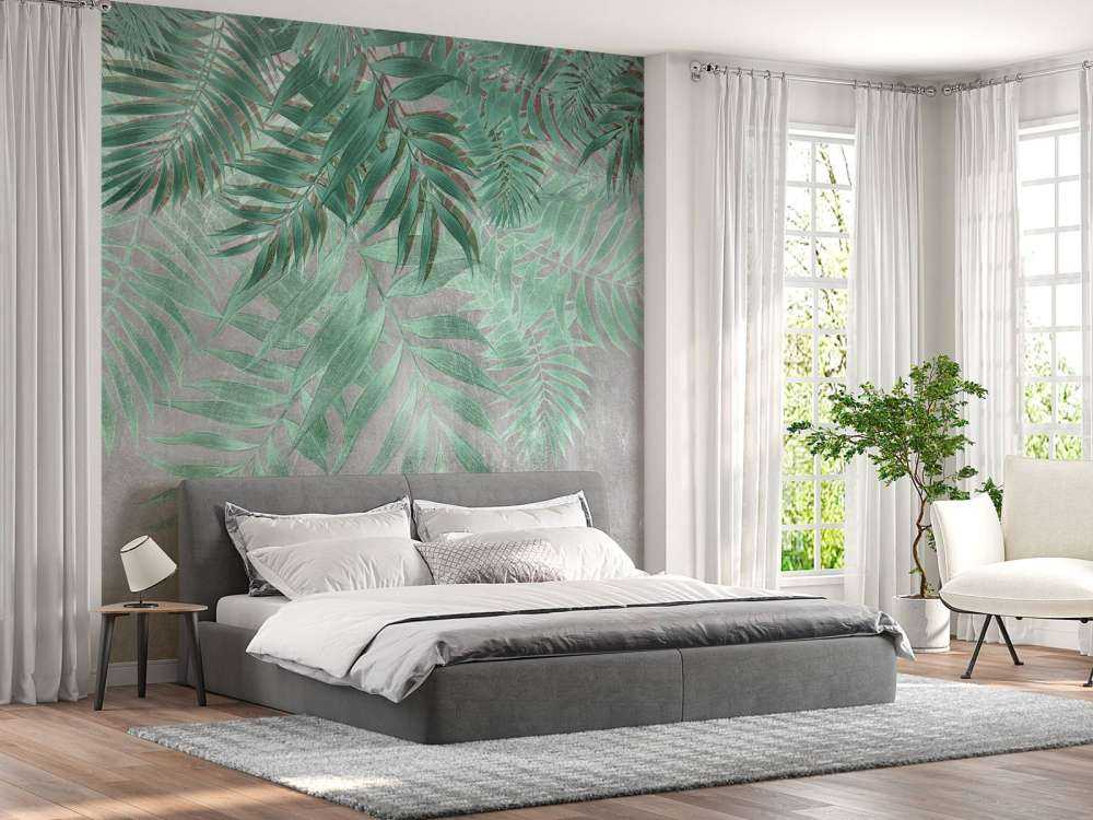 Green palm leaves with gray concrete wall