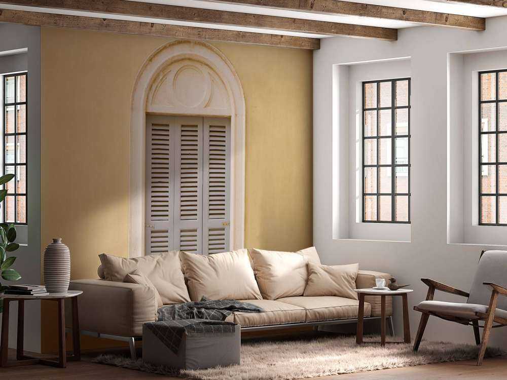 Window with wooden shutters on yellow wall