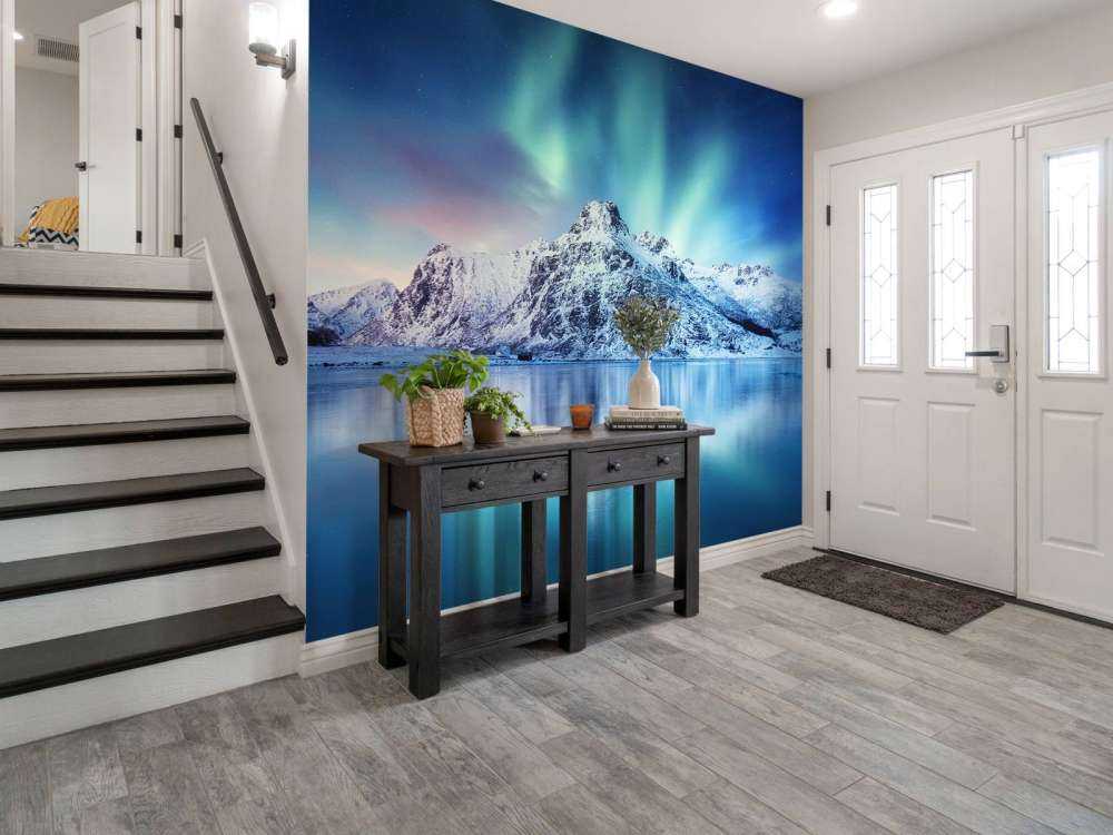 Northern lights over a frozen ocean and mountains