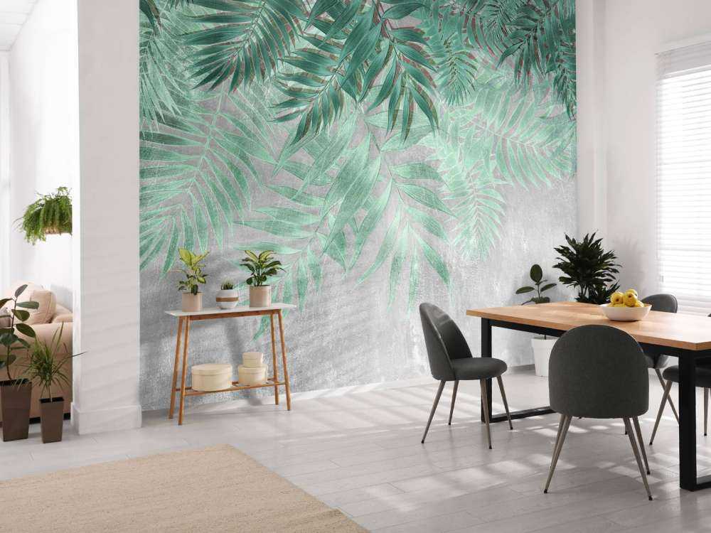 Green palm leaves with gray concrete wall