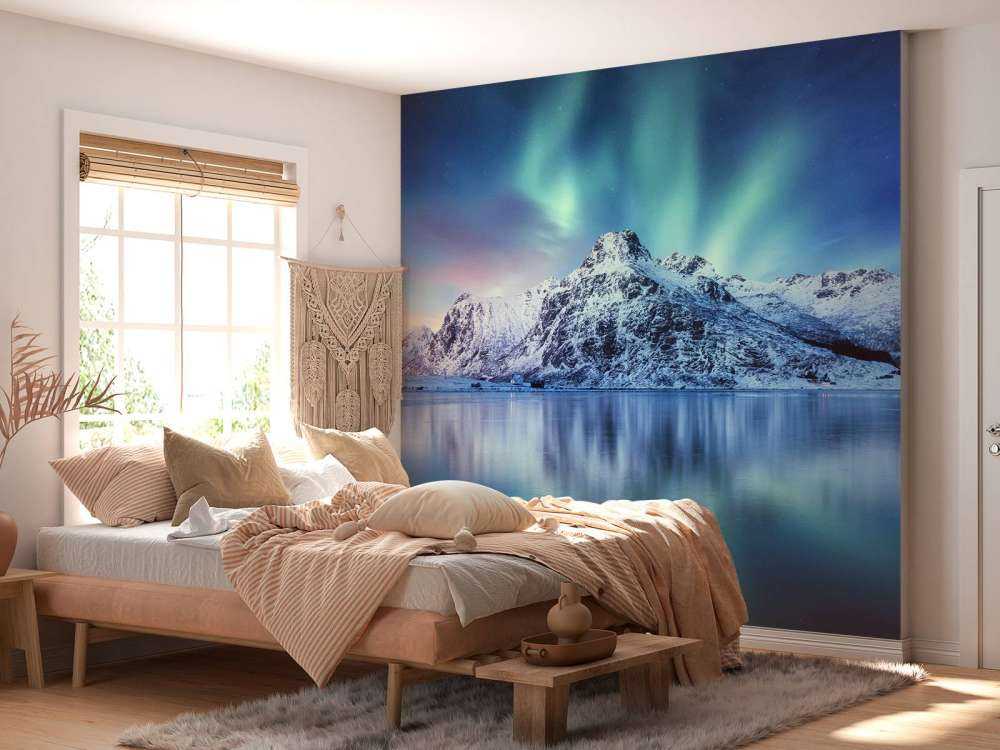 Northern lights over a frozen ocean and mountains