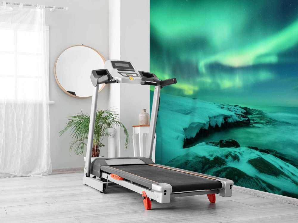 Green northern lights above snowy rocks