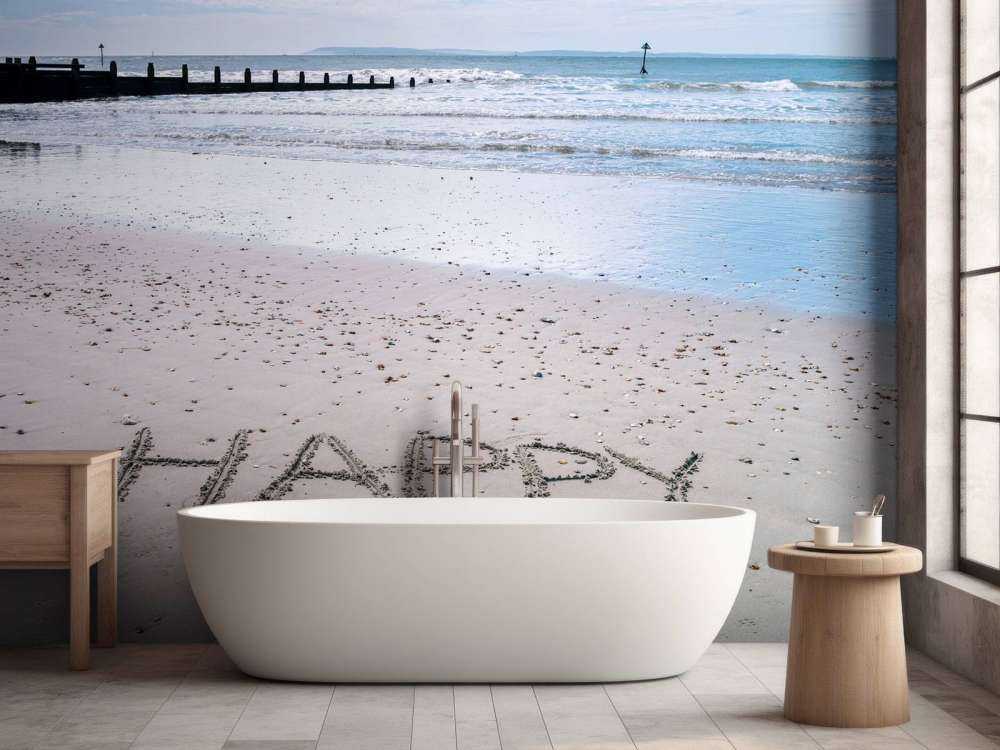 HAPPY message written in smooth sand at the beach