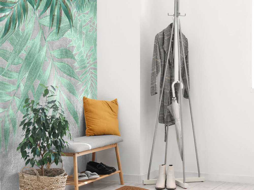 Green palm leaves with gray concrete wall