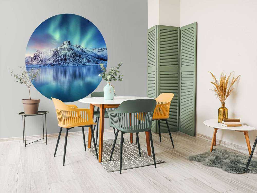 Northern lights over a frozen ocean and mountains