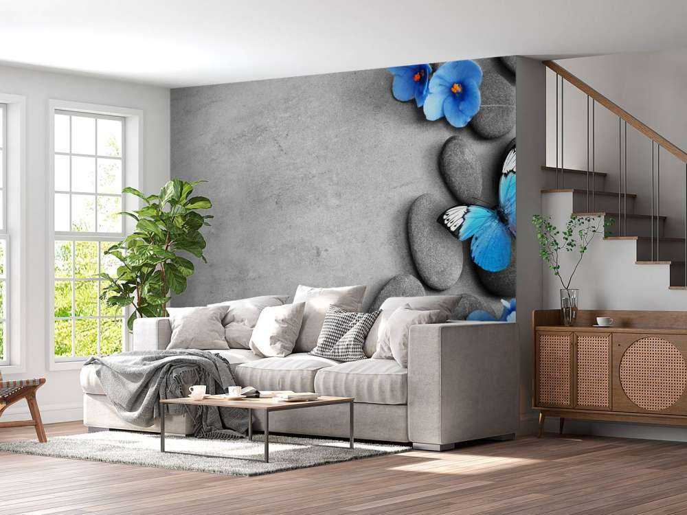 Grijze stenen met een blauwe vlinder en bloemen