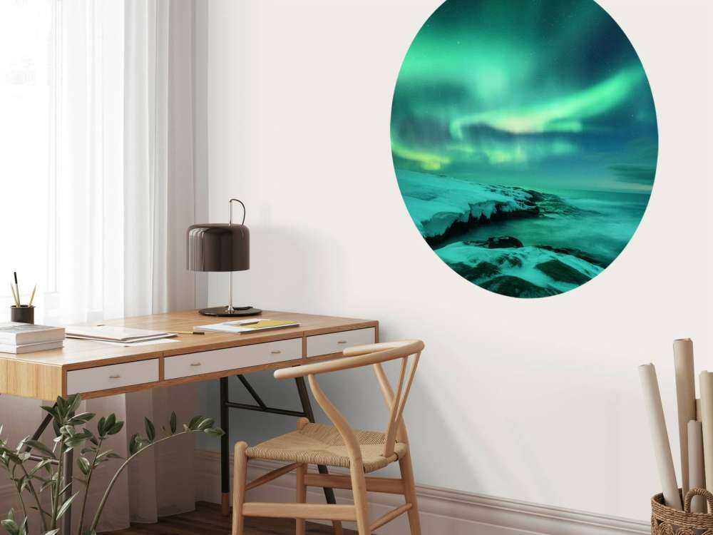 Green northern lights above snowy rocks