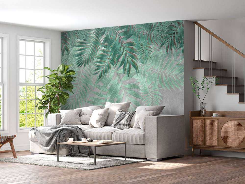 Green palm leaves with gray concrete wall