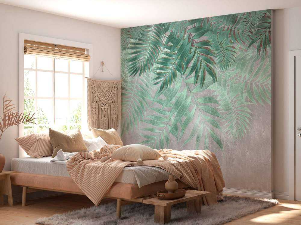 Green palm leaves with gray concrete wall