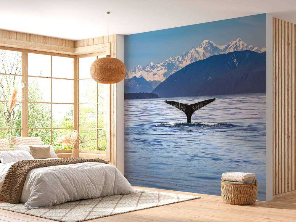 Diving whale with mountains in the background