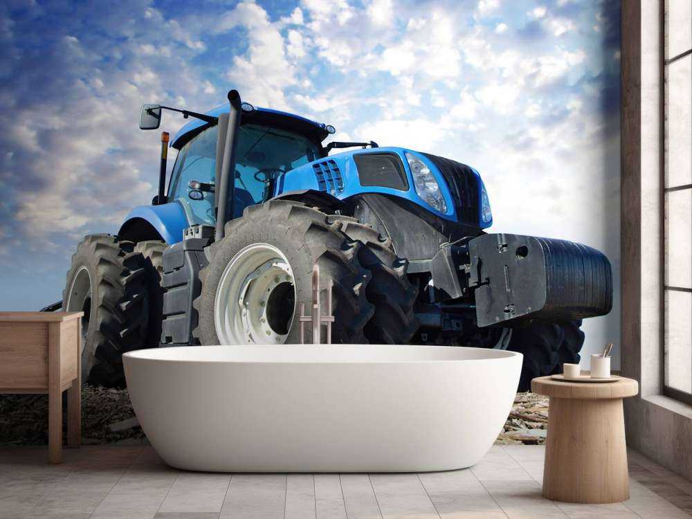 Grote blauwe tractor onder een bewolkte hemel