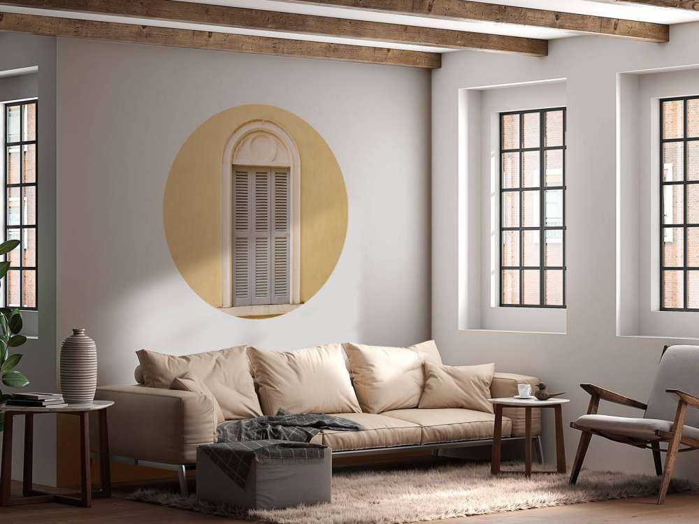 Window with wooden shutters on yellow wall